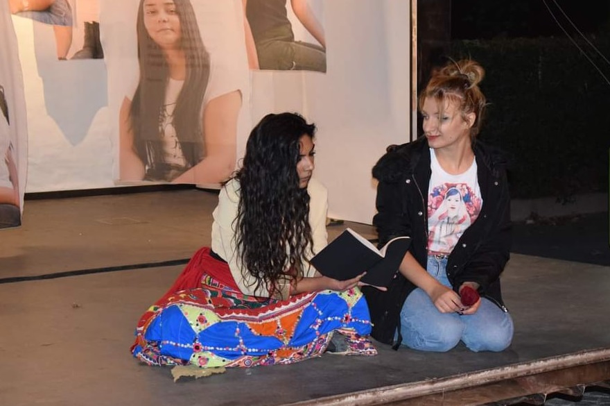 two women on the stage reading a book