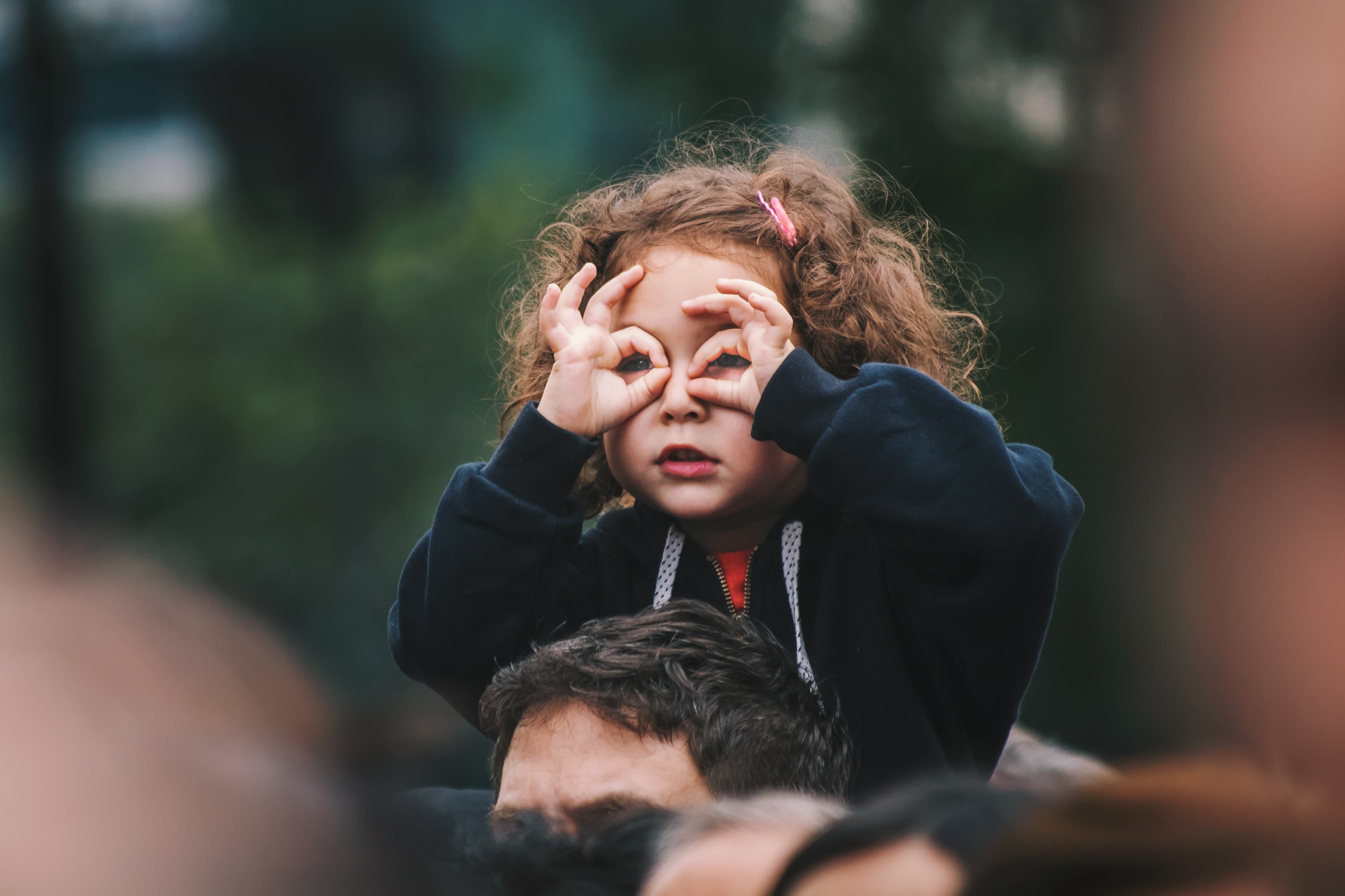 a little girl imitates binoculars with her hands