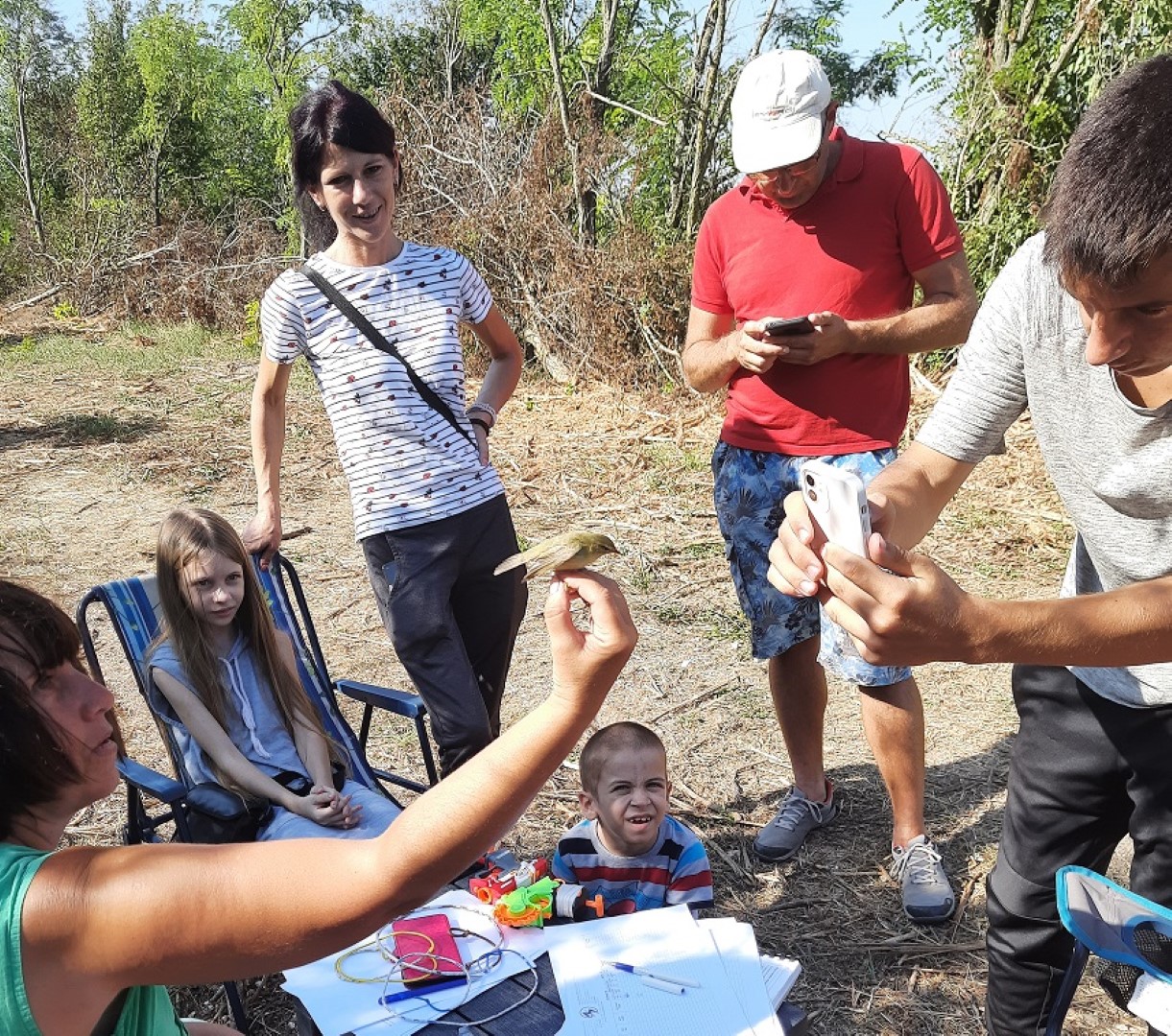 a group of children abserving a caught bird