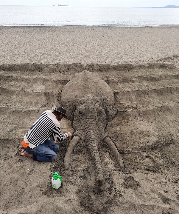 sand art artist works on the beach