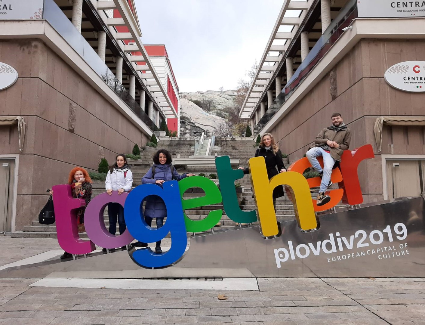 a group of people near large colourful letters