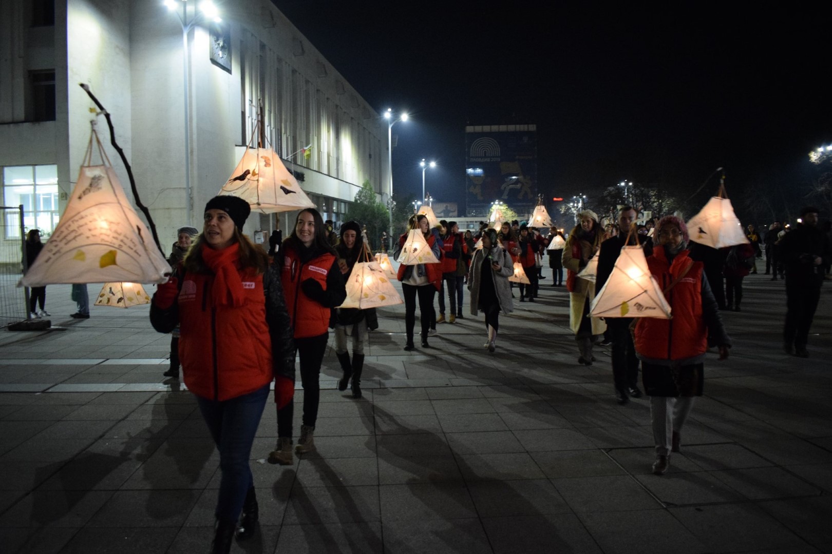 a group of people with lanterns at a night performance