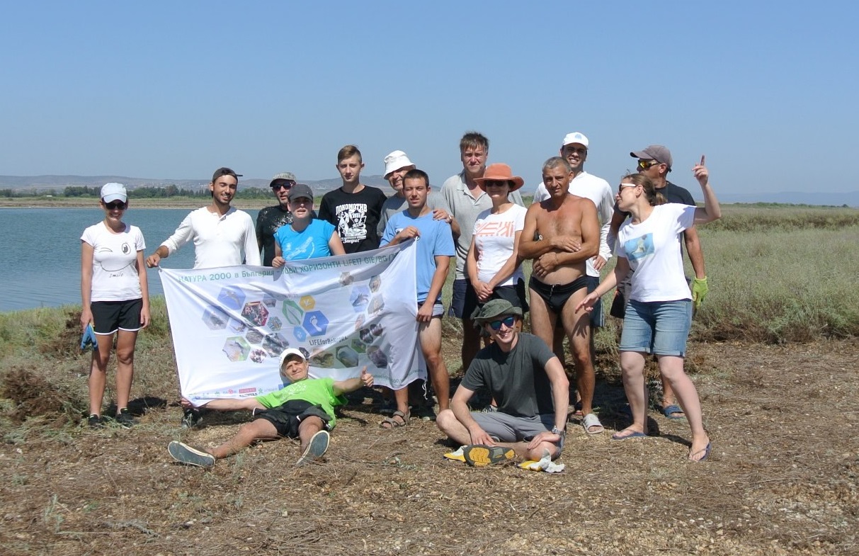 A group of volunteers with a flag of Natura 2000