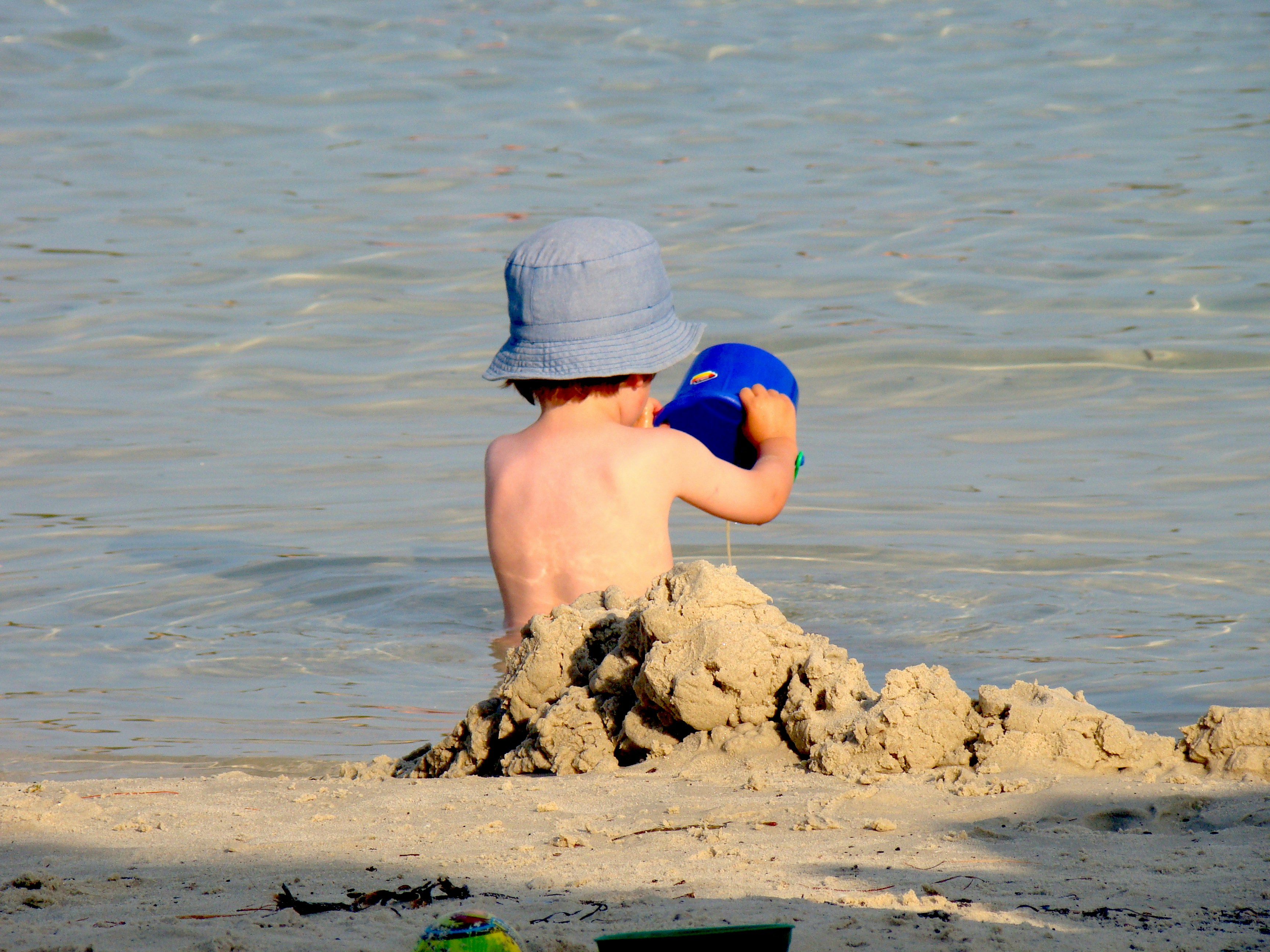 figures of a sandy mermaid and dolphins on the beach