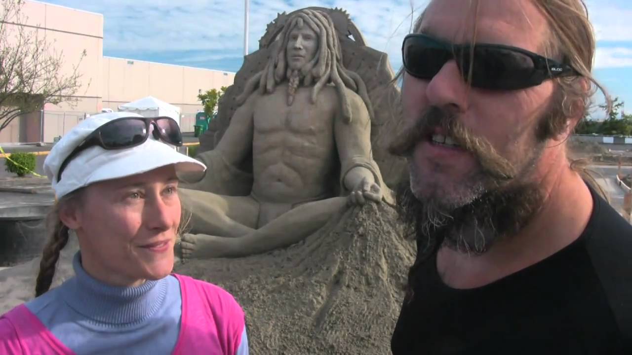 a couple against the background of sand sculptures